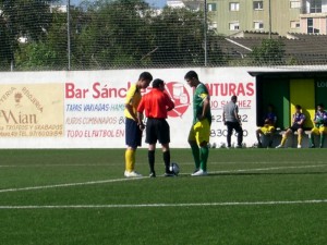 El colegiado con los capitanes del partido